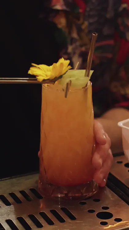 Cóctel con una flor amarilla sobre la barra, portada de un recap de noche de muestra