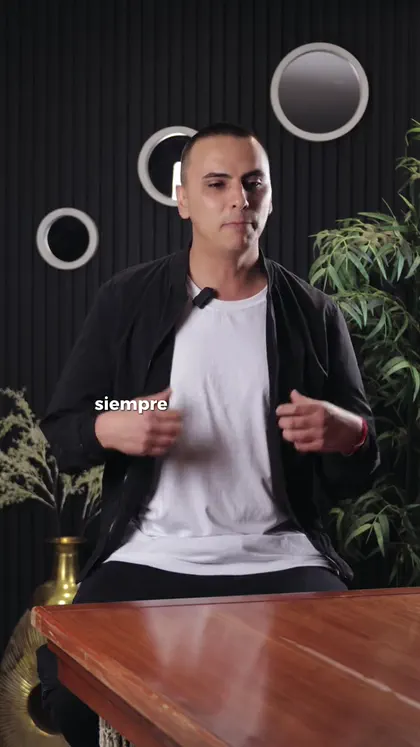 Hombre sentado frente a una mesa de madera al empezar la entrevista de muestra