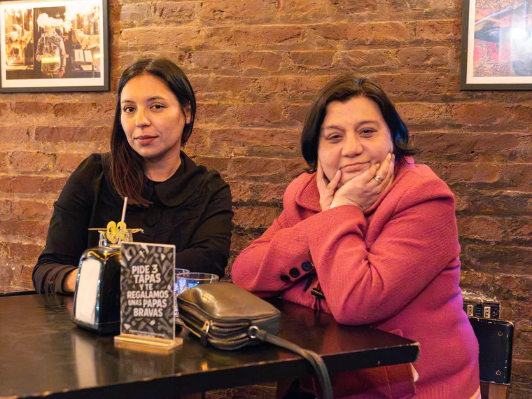 Clientas en una mesa de Bar del Tío junto al muro de ladrillo del local