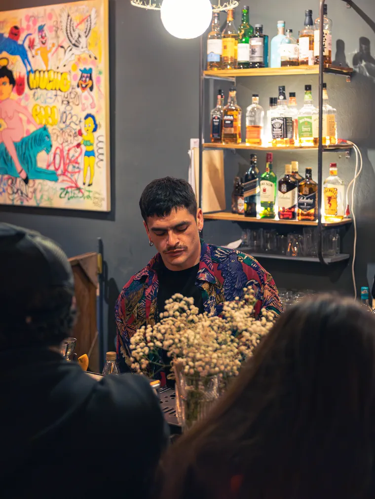 Bartender de Bar del Tío trabajando detrás del arreglo de flores de la barra