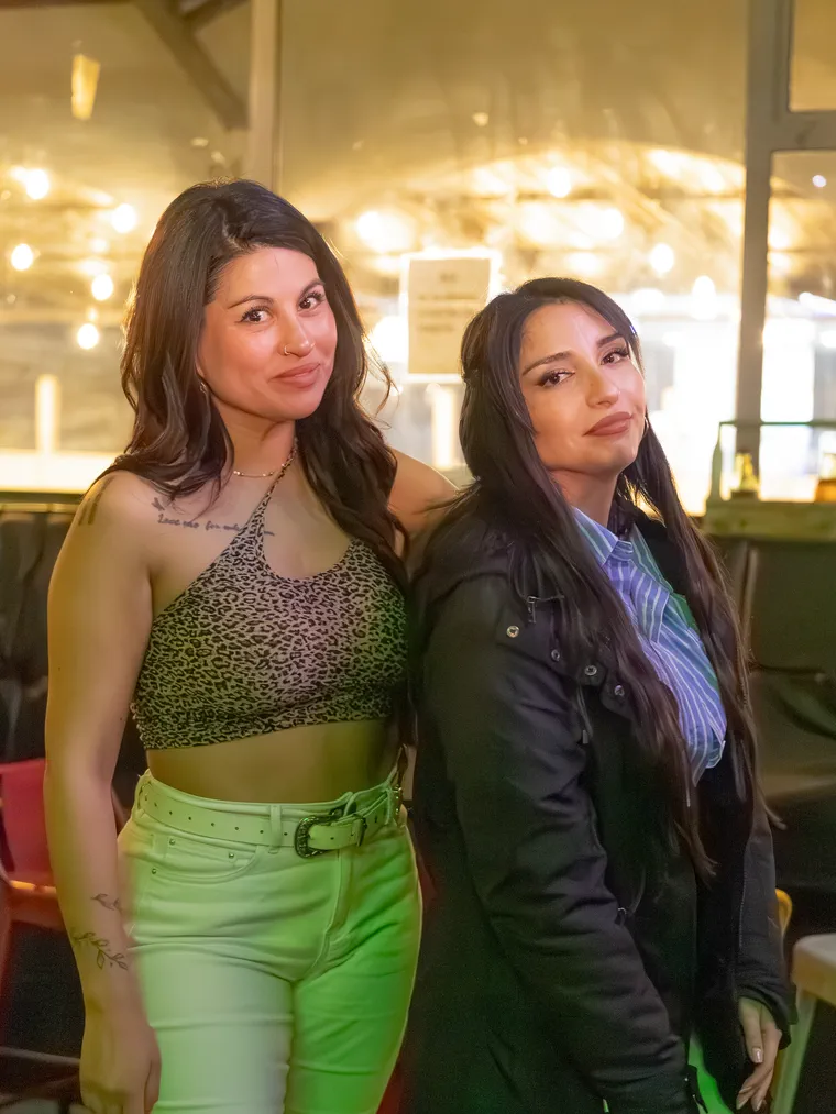 Dos amigas posan sonriendo en un evento de noche, cobertura de eventos sociales en la región de Valparaíso