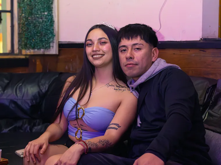 Pareja posando en el sillón de un bar de Valparaíso durante la noche, cobertura del local
