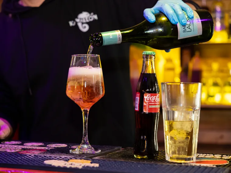 Espumante sirviéndose en la copa sobre la barra de un bar de Valparaíso, cuadro del video de la noche