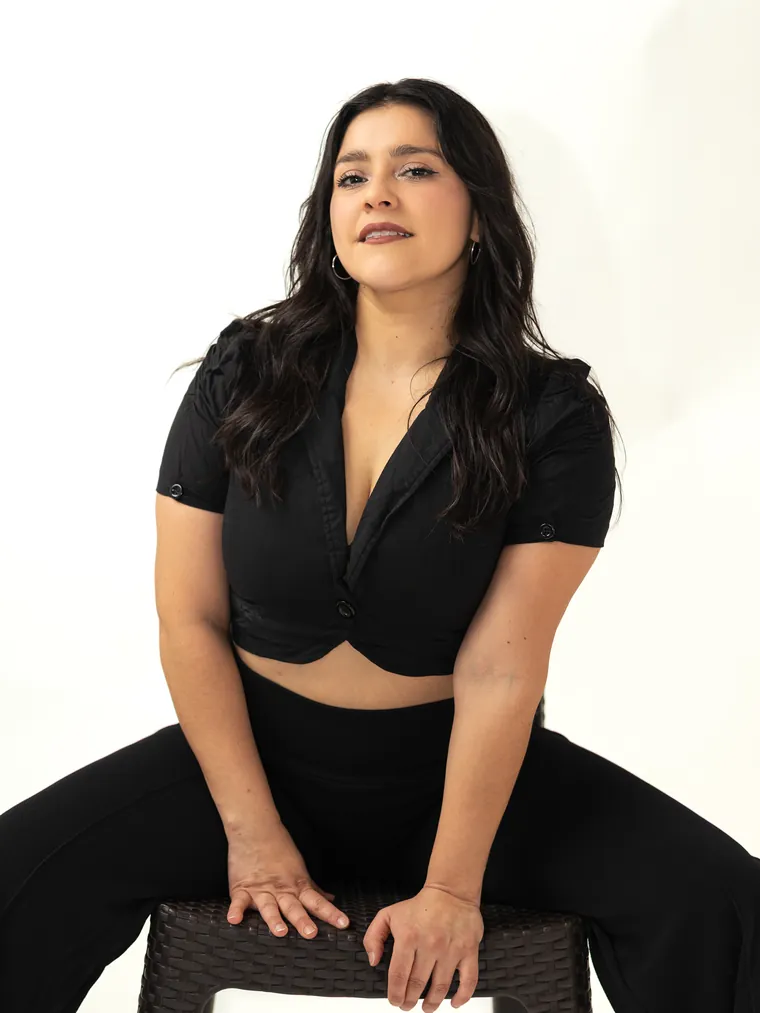 Retrato en estudio de una mujer de negro sentada en un piso, sesión de fotografía de danza