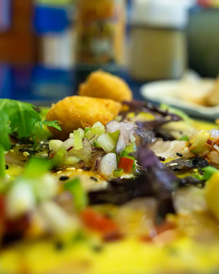 Pescado picado con cebolla y hojas moradas en primer plano, fotografía gastronómica para un bar