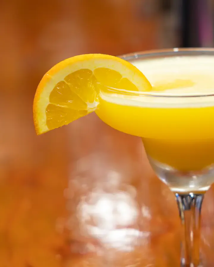 Trago naranja en copa de pie con rodaja de naranja en el borde, sesión de producto en Valparaíso