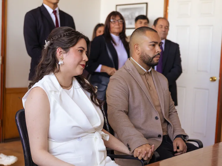 Los novios sentados juntos entre los invitados durante la ceremonia civil
