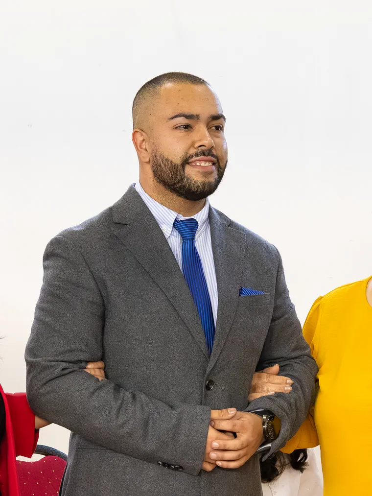 El novio de terno gris y corbata azul espera de pie en la iglesia el día de su matrimonio