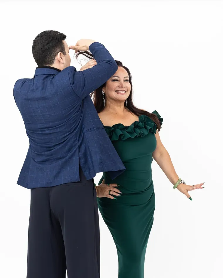 Hombre de blazer azul y mujer de vestido verde posando en estudio, sesión de retrato en Valparaíso