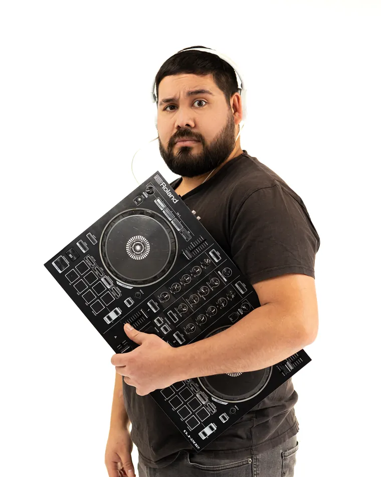 Sesión de marca personal en estudio: hombre con audífonos y un controlador de dj en brazos