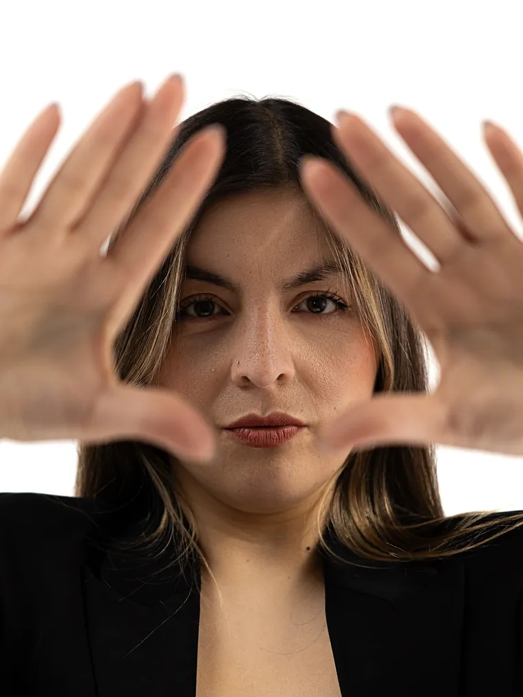 Sesión de marca personal en Valparaíso: mujer de blazer negro enmarca su cara con las manos, seria