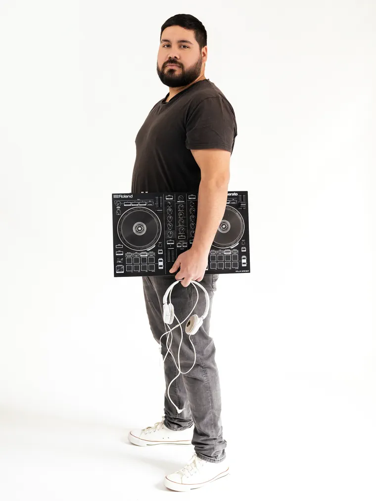 Sesión de marca personal: hombre de pie con su controlador de dj sobre fondo blanco