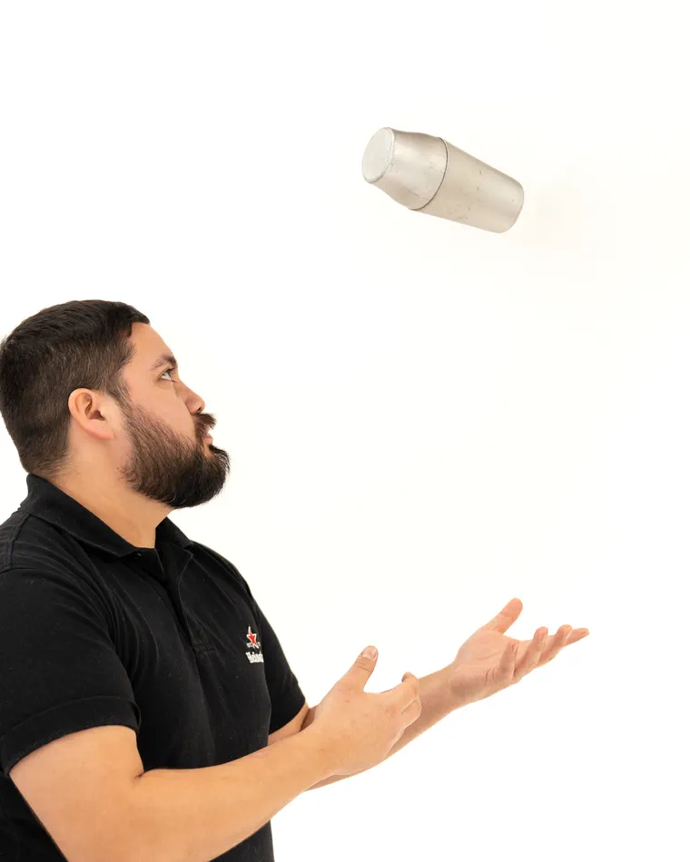 El barbero lanza al aire un frasco de producto, en el estudio